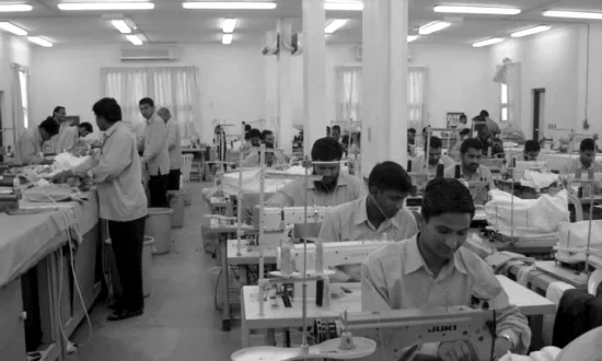 Rows of machinists at industrial sewing machines in the TSC workshop